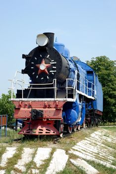 The ancient steam locomotive stands on a pedestal