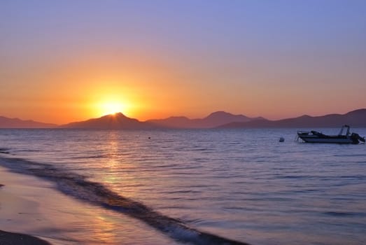 Sun is setting behind the mountains and sea