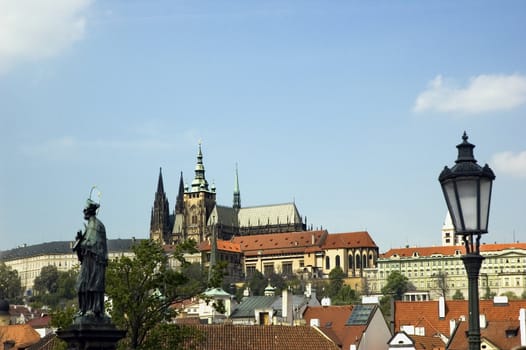 Prague castle from the Charles bridge with a detail of lantern and statue of saint John