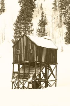 Old mining hut in mountains with snow