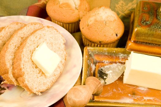 Bread slices and muffins with butter and plate
