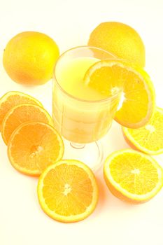 Glass of orange juice surounded by oranges
