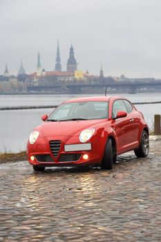 Red car parked on the background of the city, Riga, Latvia