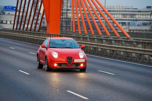 Red car driving in the city on cable bridge, Riga, Latvia