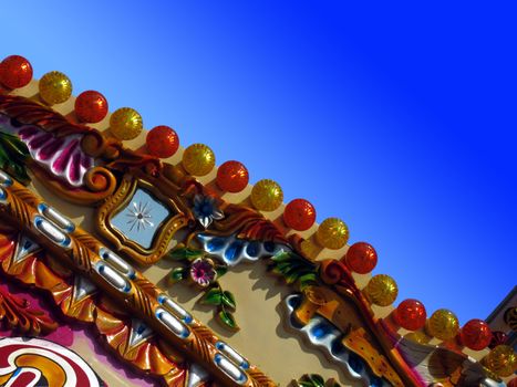 Detail from a beachside merry-go-round against a clear blue summer sky. Ideal for evocative summer memory concepts.