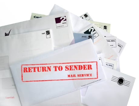 Return to sender. A pile of mail, possibly junk mail, or the recipient has gone away. The most prominent envelope is marked return to sender