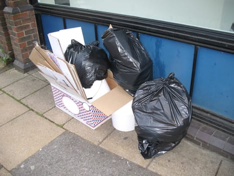 Cardboard boxes and plastic bags left out to be collected by refuse collectors
