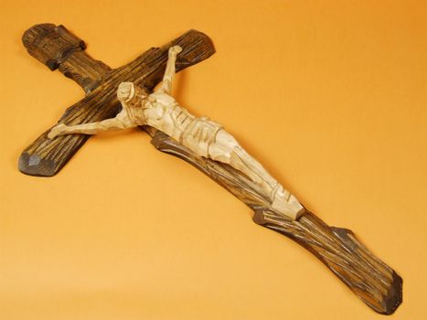 Wooden carved cross with crucified Jesus Christ. Religious symbol of catholic beliefs. Artistic icon.