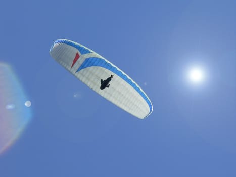 paragliding in a blu ski with sun