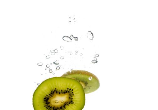 Splash of green kiwi slice to water with bubbles of air