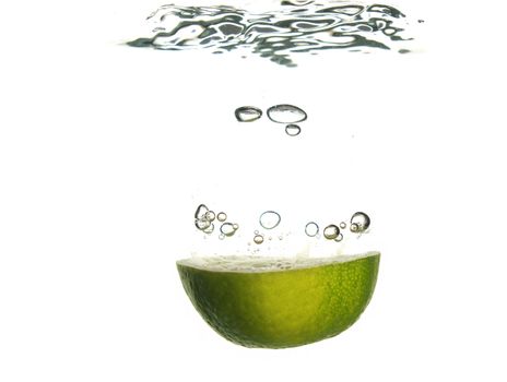 Splash of green lemon to water with bubbles of air