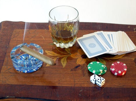 Scotch, cards, dice, poker chips, and a cigar.