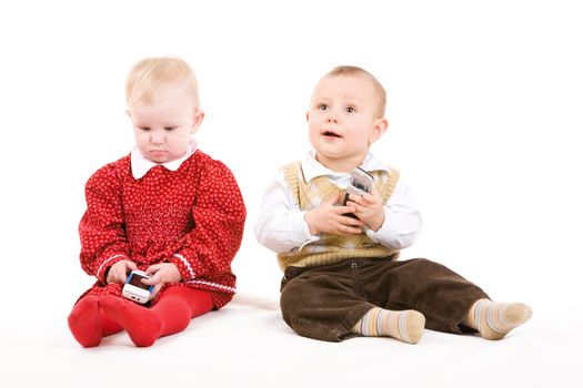 two children on the floor with phones
