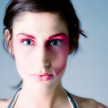 Close studio portrait of a pretty brunette with special artistic cosmetics