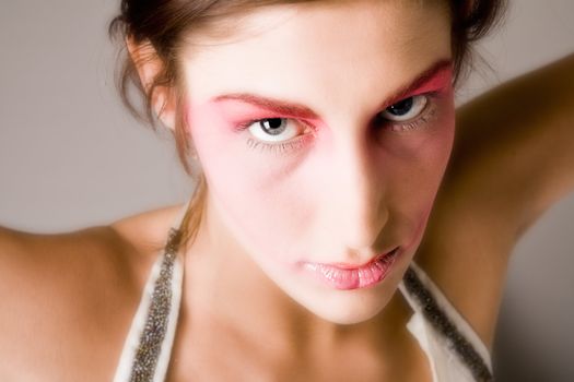 Close studio portrait of a pretty brunette with special artistic cosmetics