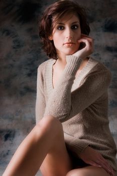 Studio portrait of a long brunette dressed in only a sweater