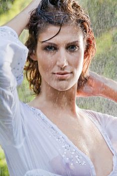Brunette in see through blouse standing in the rain