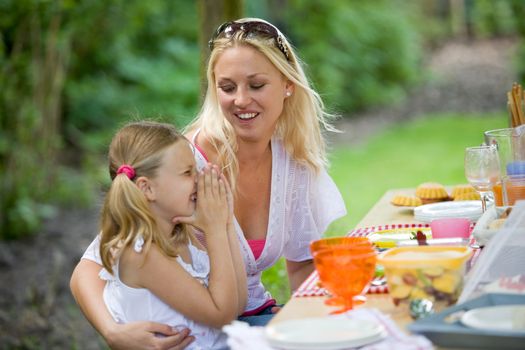 Young girl having fun with mom at the picknicktable (shallow dof, focus on mother)