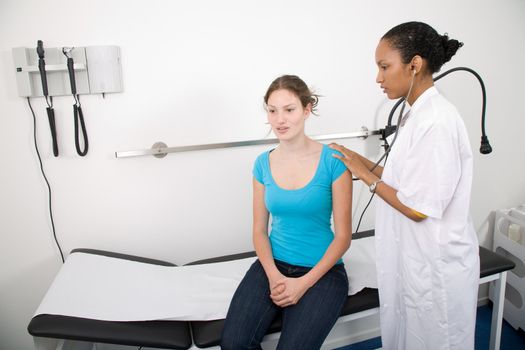 Young brunette being examined by her pediatrician