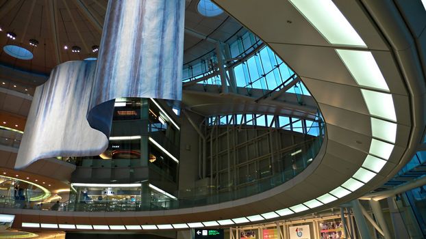 futuristic atrium environment, glass wall and metallic construction inside big public hall with sitting man