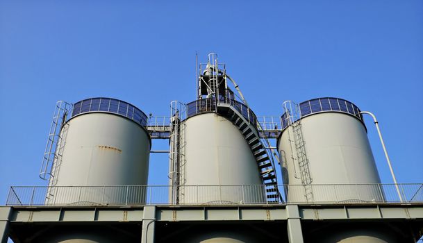 huge industrial reservoir barrels on the blue sky background