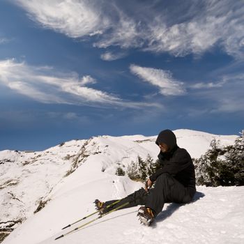 Man sit and rest on white snow mountain peak.