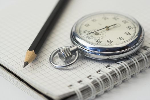 chronometer and black  pen over notebook