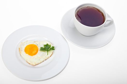 heart shaped fried egg and a cup of tea