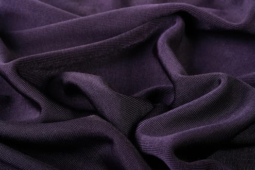 Darkly violet fabric as a background for design works.