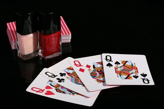 Four playing cards with ladies, a pack and two small bottles with nail polish.