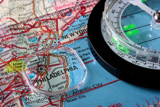 USA map with the city of Philadelphia and a compass with magnifying glass over Philadelphia.
