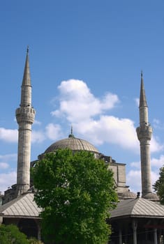 Muslim mosque over green tree with blue sky