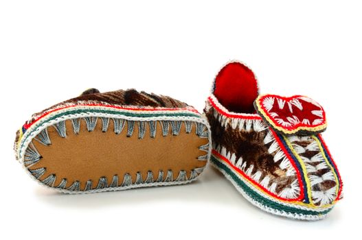 Baby's (childs) embroidered mocassins with leather sole on overwhite background.