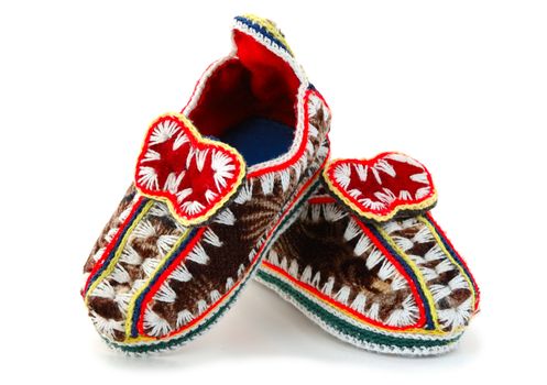 Baby's (childs) embroidered mocassins with leather sole on overwhite background.