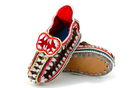 Baby's (childs) embroidered mocassins with leather sole on overwhite background.