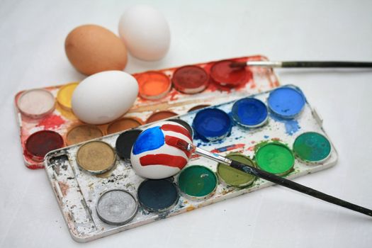 Stars and stripes, painted on a patriotic easter egg and some other colors of paint