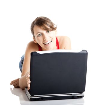 Beautiful and happy young woman lying on floor and working on a laptop