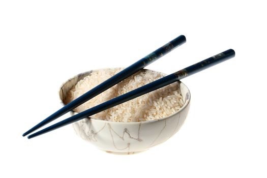 Rice in teabowl with dark blue chopsticks on a white background.