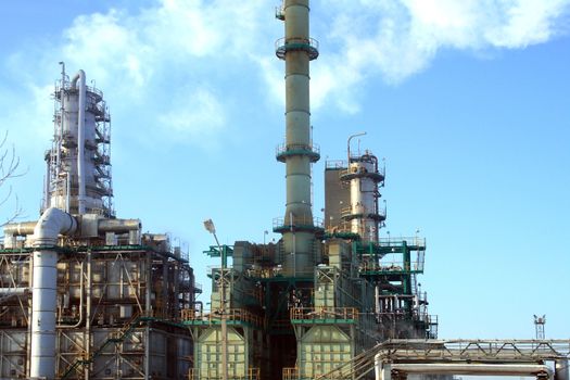 Closeup of oil refinery construction on background with blue sky