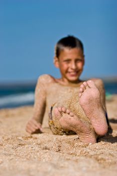 leisure seies: sandy boy's foot on summer sea beach