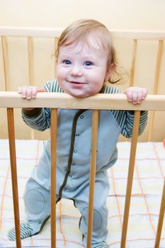 Funny baby boy standing in his bed