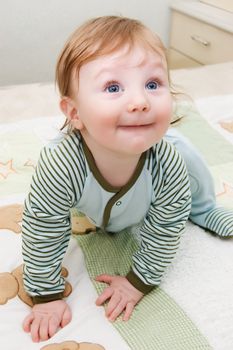 Curiously looking up toddler lying on bed