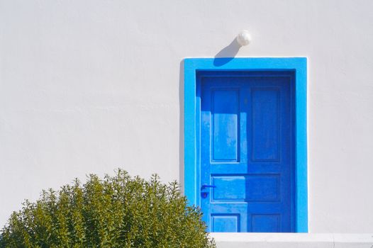 Abstract close-up of Santorini home wall, door and lamp.