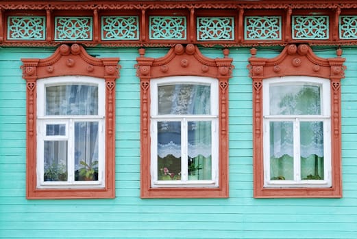 Windows of wooden building with traditional for Russian village trimming