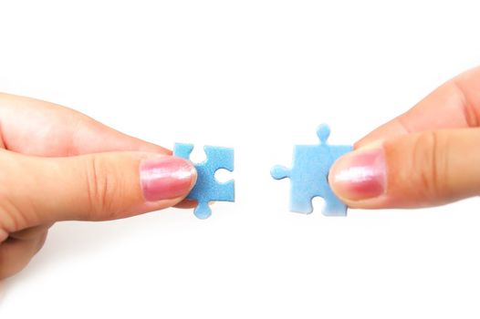 female hands putting together right puzzle isolated on white