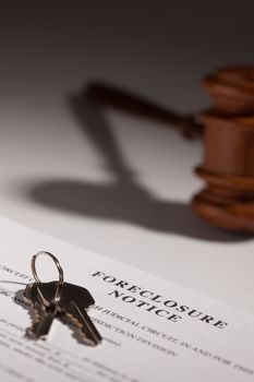 Foreclosure Notice, Gavel and House Keys on Gradated Background with Selective Focus.