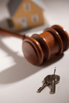 Gavel, House Keys and Model Home on Gradated Background with Selective Focus.