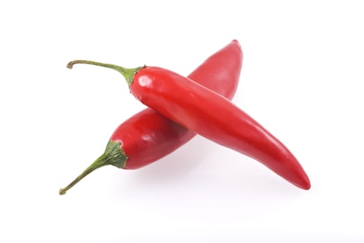 Two red chili peppers isolated on a white background.