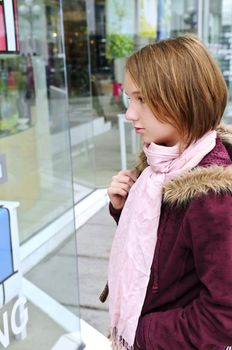 Teenage girl window shopping on city street