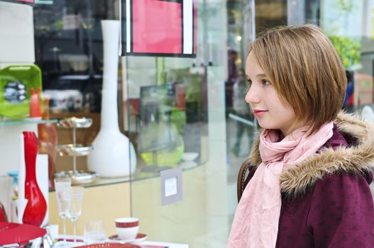 Teenage girl window shopping on city street